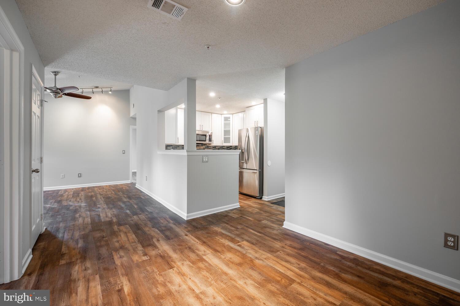 12024 Taliesin Place, Unit 33 Reston, VA 20190 - Photo 3 of 32 a view of a kitchen with a sink refrigerator and wooden floor