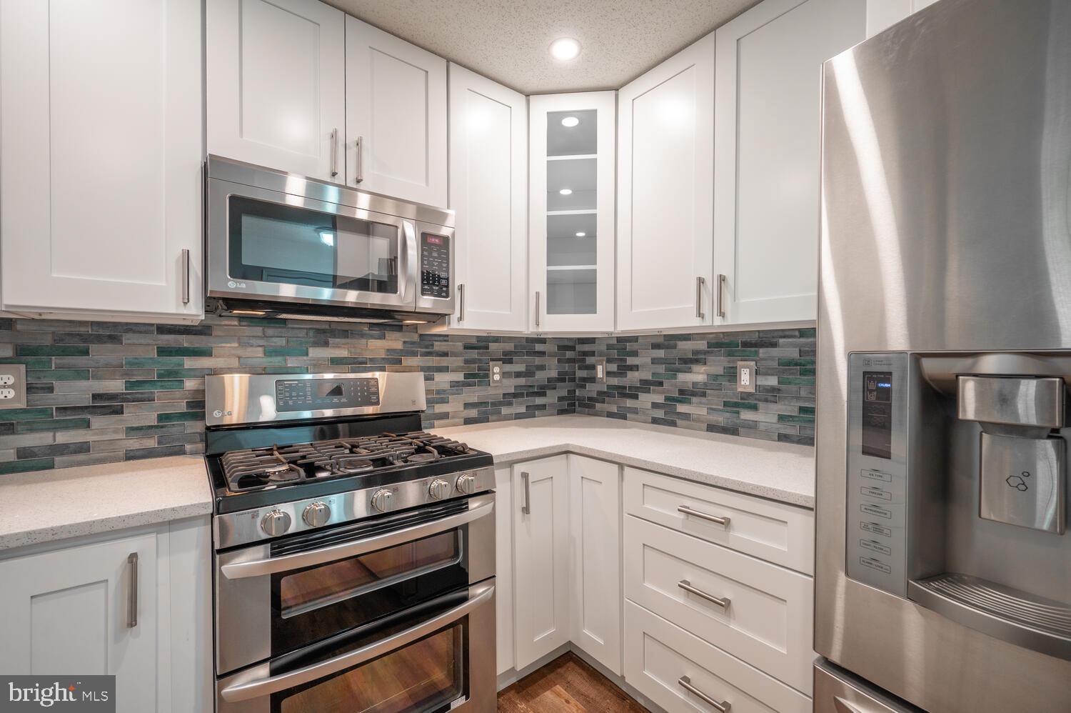 12024 Taliesin Place, Unit 33 Reston, VA 20190 - Photo 8 of 32 a kitchen with stainless steel appliances white cabinets and a stove top oven