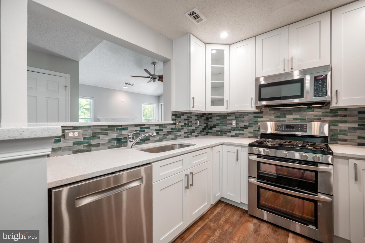 12024 Taliesin Place, Unit 33 Reston, VA 20190 - Photo 9 of 32 a kitchen with cabinets stainless steel appliances a sink and a window