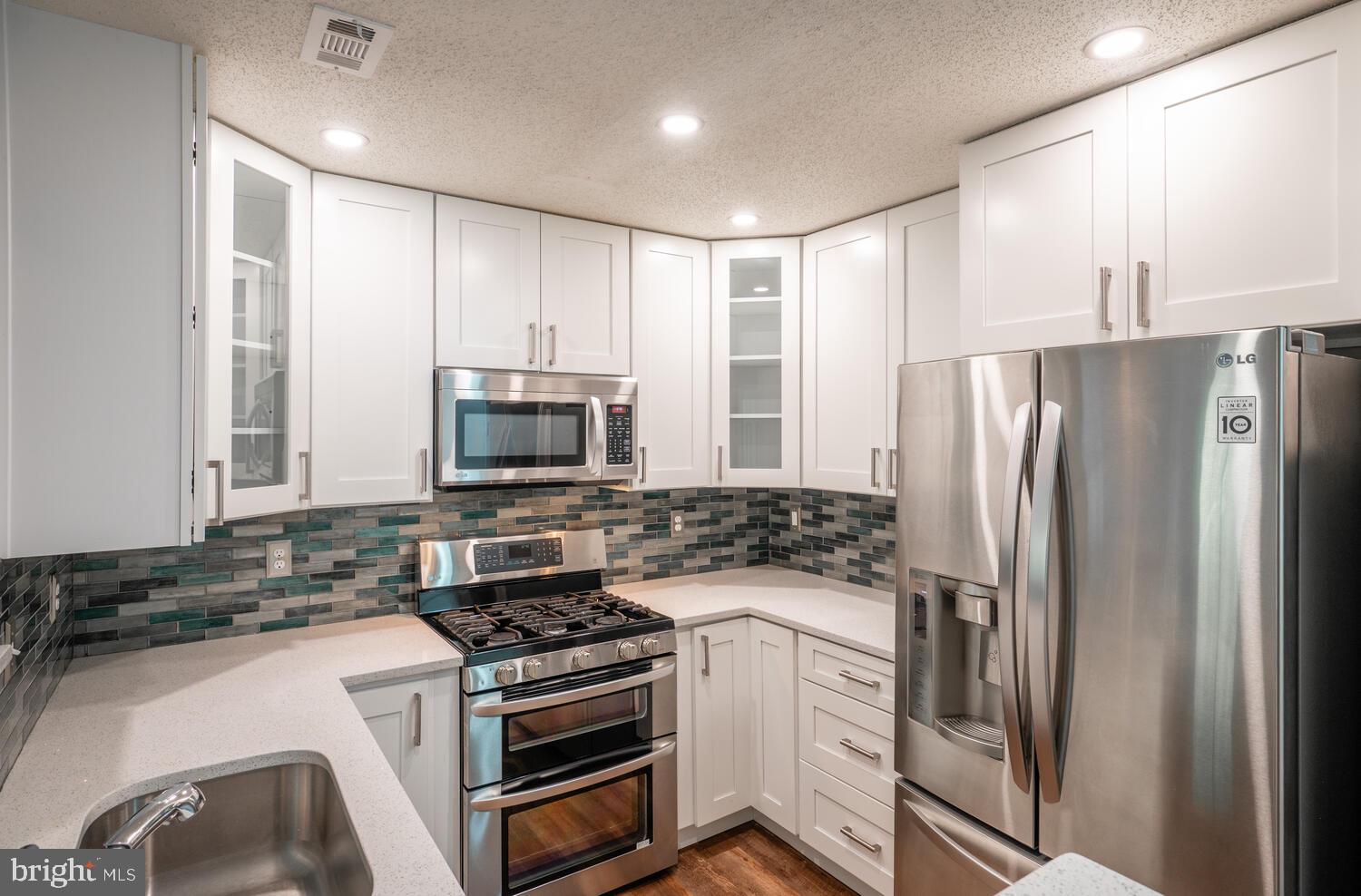 12024 Taliesin Place, Unit 33 Reston, VA 20190 - Photo 10 of 32 a kitchen with stainless steel appliances a refrigerator stove and microwave