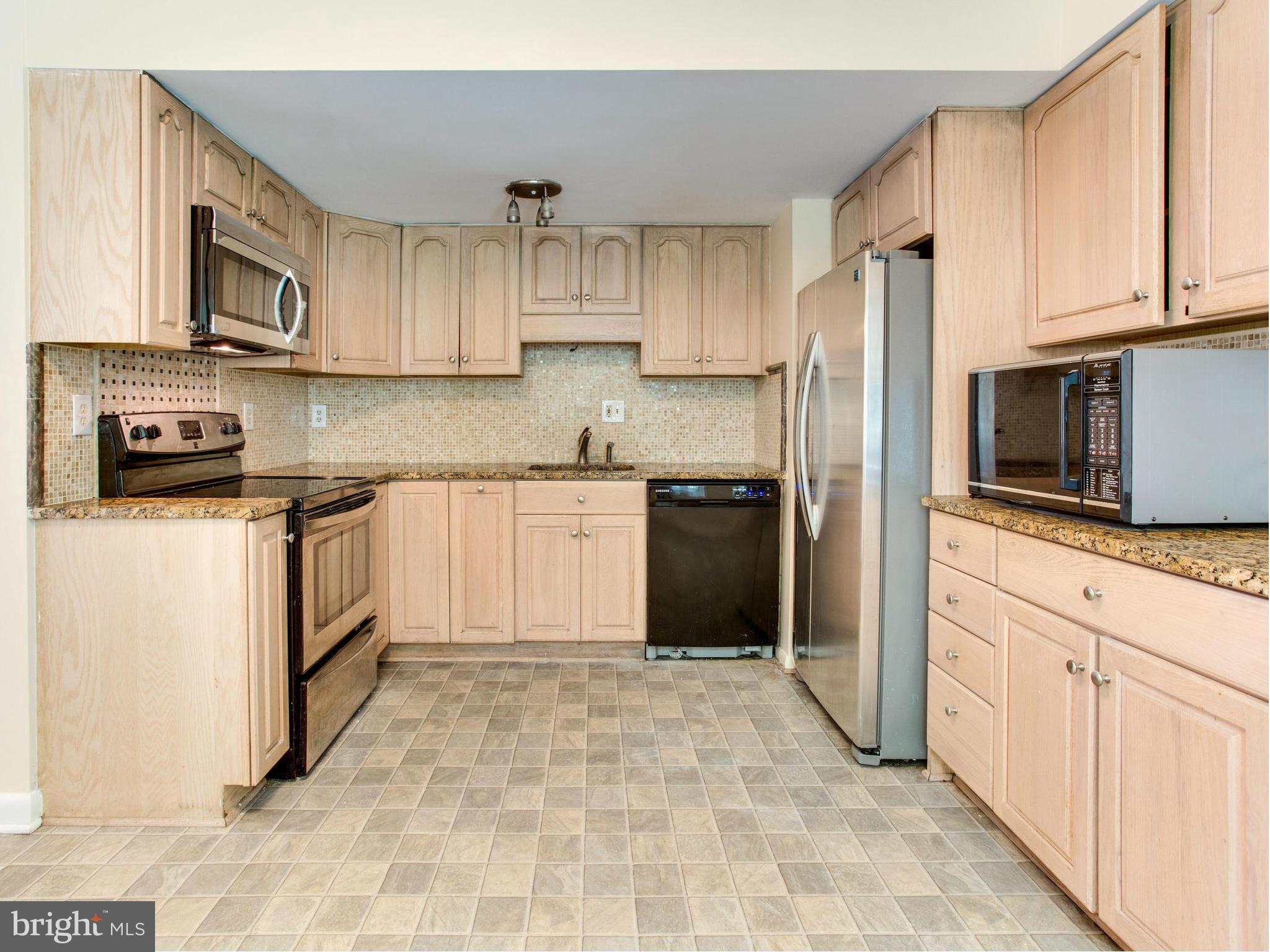 2308 St Bedes Court Reston, VA 20191 - Photo 11 of 30 a kitchen with stainless steel appliances granite countertop a stove a sink and a microwave