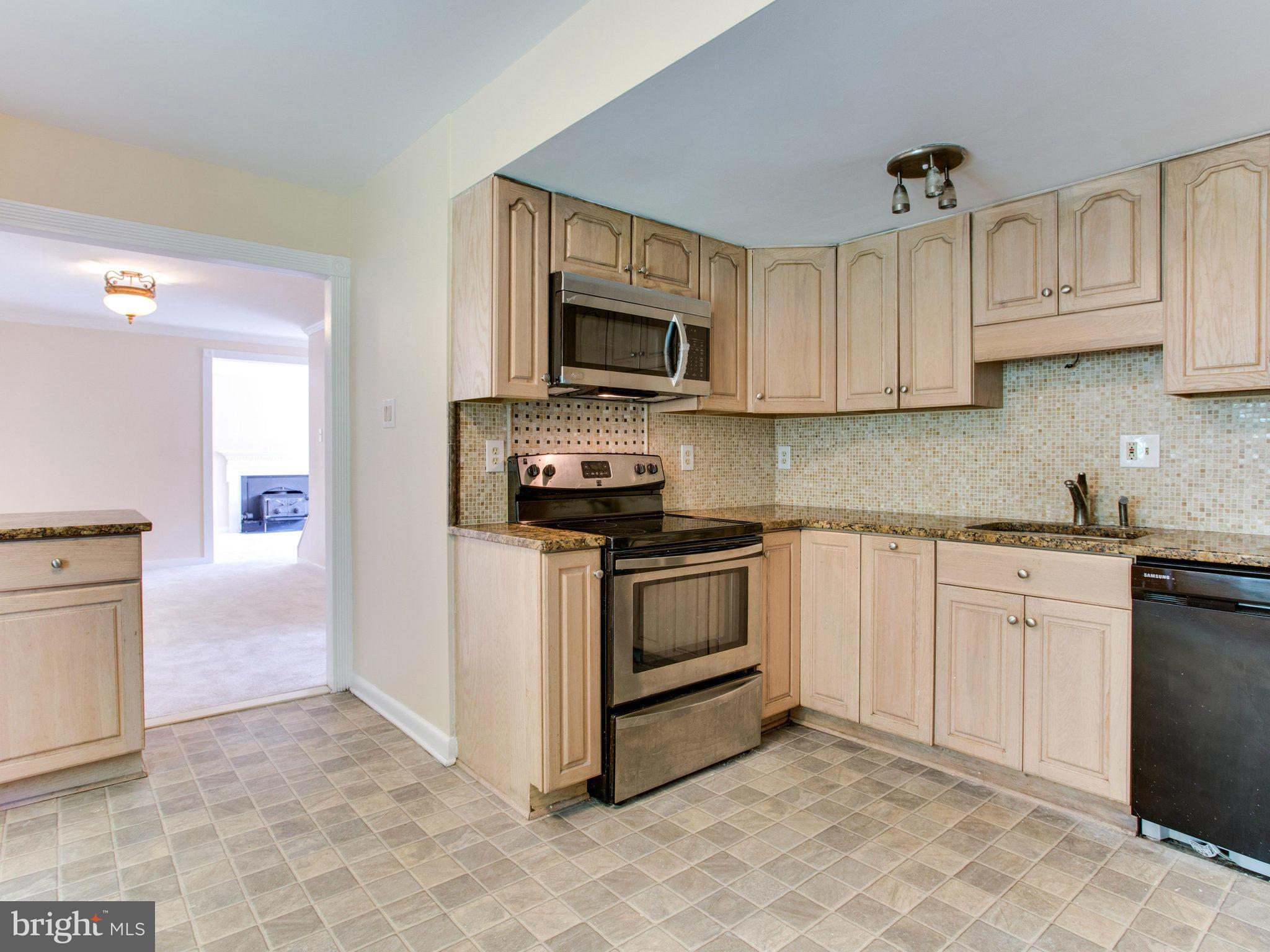 2308 St Bedes Court Reston, VA 20191 - Photo 12 of 30 a kitchen with stainless steel appliances granite countertop a stove a sink and a microwave