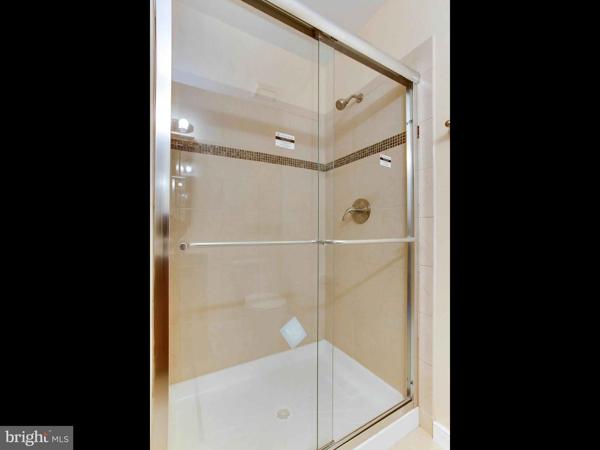 2308 St Bedes Court Reston, VA 20191 - Photo 16 of 30 a bathroom with a glass shower door and a mirror