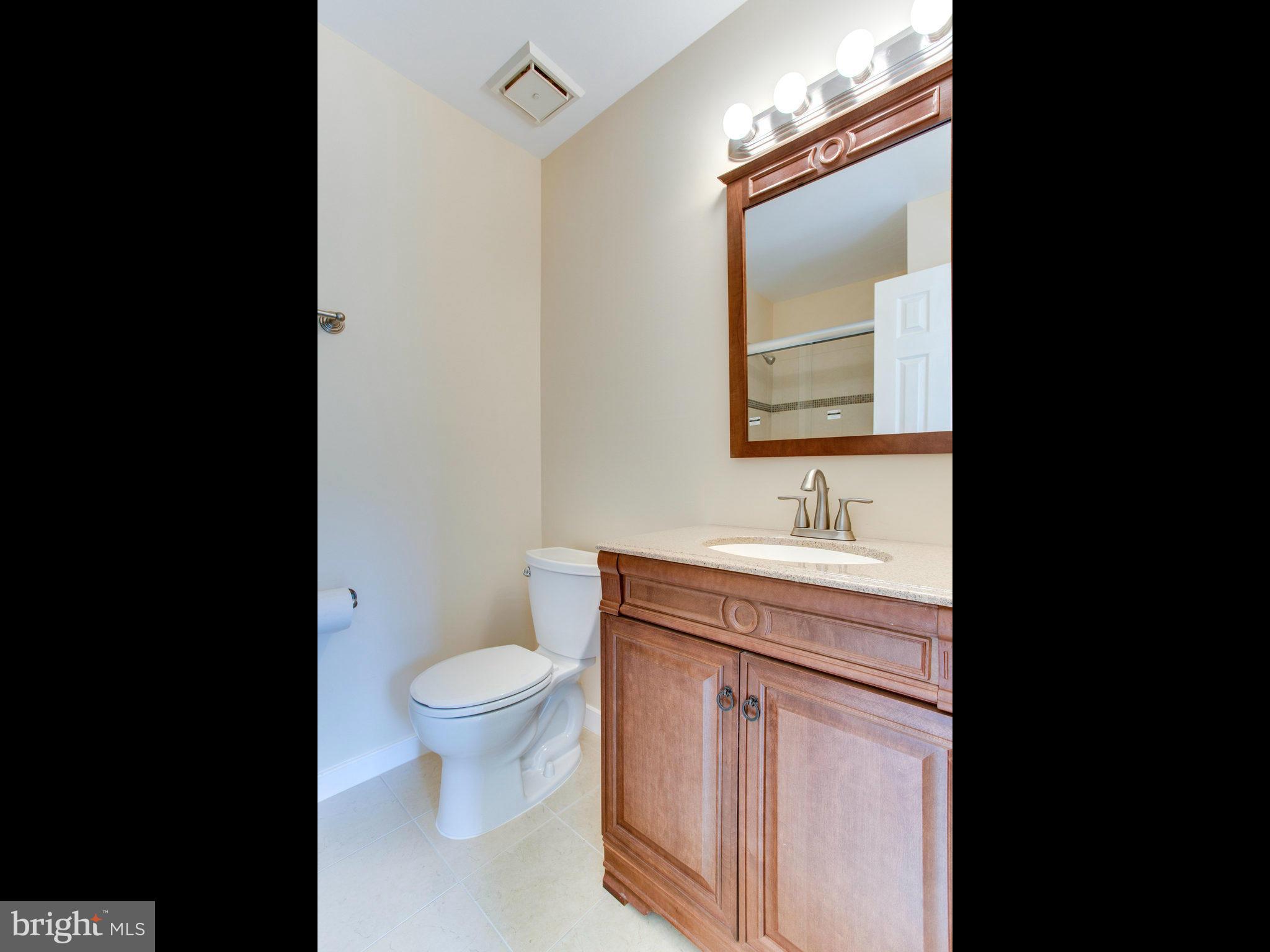 2308 St Bedes Court Reston, VA 20191 - Photo 17 of 30 a bathroom with a granite countertop sink a toilet and a mirror