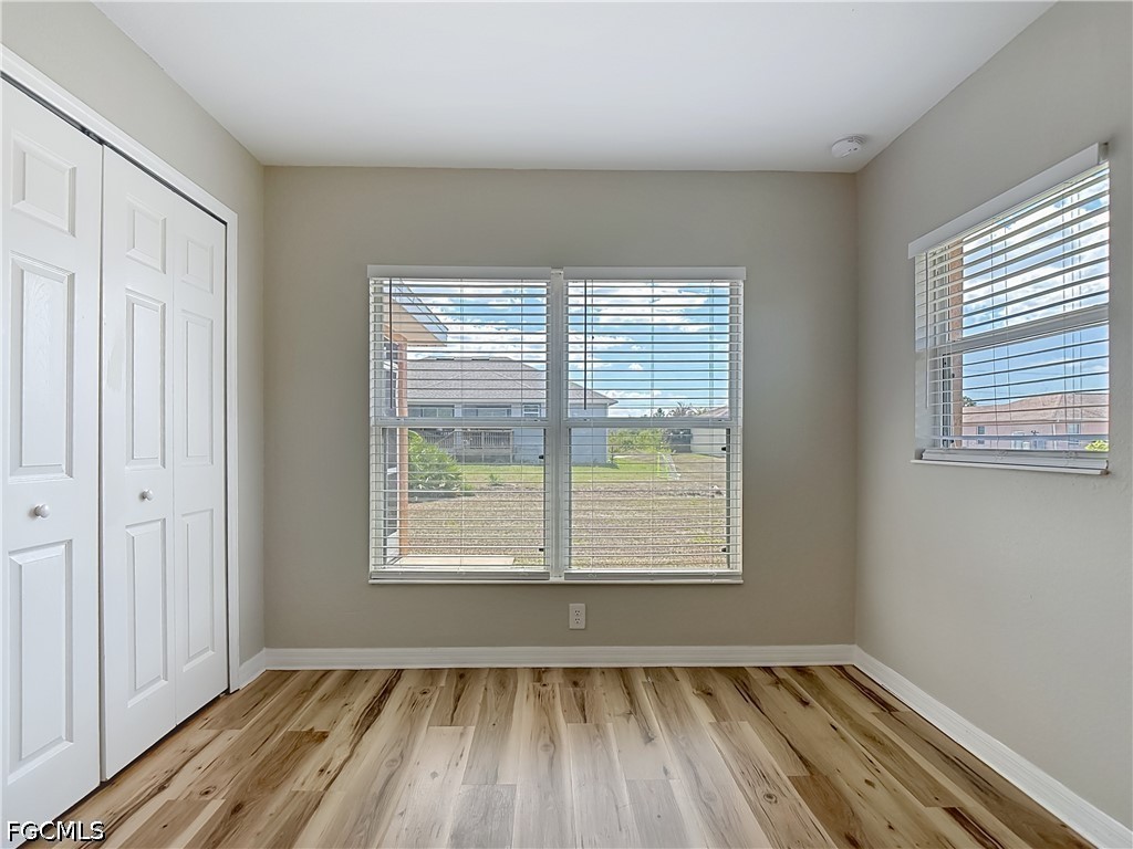 3713 20th Street Southwest Lehigh Acres, FL 33976 - Photo 17 of 23 a view of an empty room with wooden floor and a window