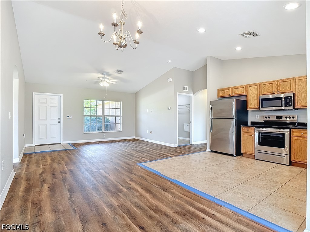 3713 20th Street Southwest Lehigh Acres, FL 33976 - Photo 4 of 23 a view of a kitchen with a stove cabinets and wooden floor
