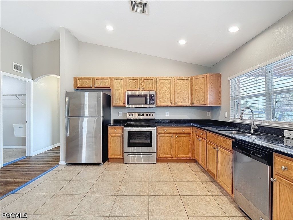 3713 20th Street Southwest Lehigh Acres, FL 33976 - Photo 6 of 23 a kitchen with stainless steel appliances granite countertop a refrigerator a sink a stove a microwave and island