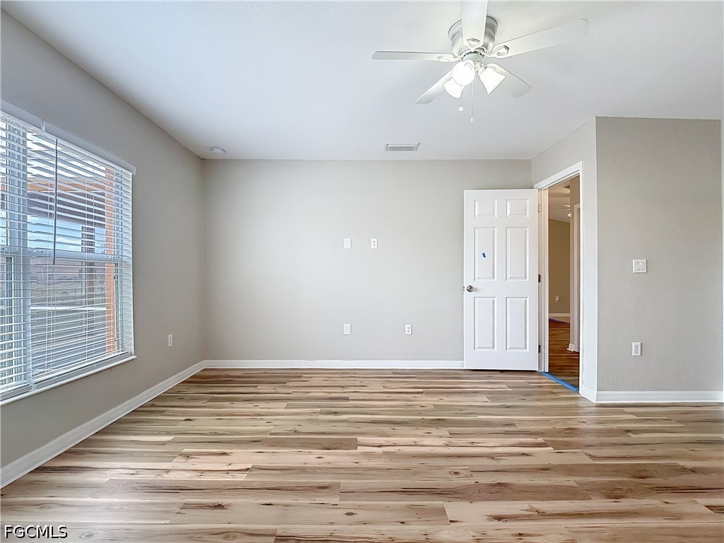 3713 20th Street Southwest Lehigh Acres, FL 33976 - Photo 8 of 23 a view of a room with wooden floor and a ceiling fan