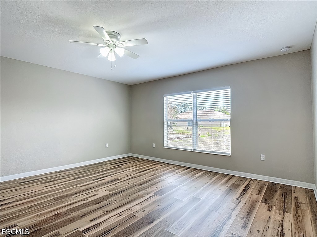 3713 20th Street Southwest Lehigh Acres, FL 33976 - Photo 9 of 23 a view of an empty room with wooden floor and a window