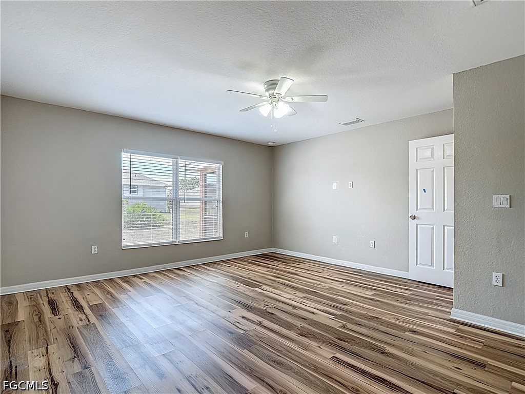 3713 20th Street Southwest Lehigh Acres, FL 33976 - Photo 10 of 23 a view of empty room with wooden floor and fan