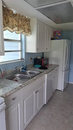 a kitchen with stainless steel appliances a table and chairs in it