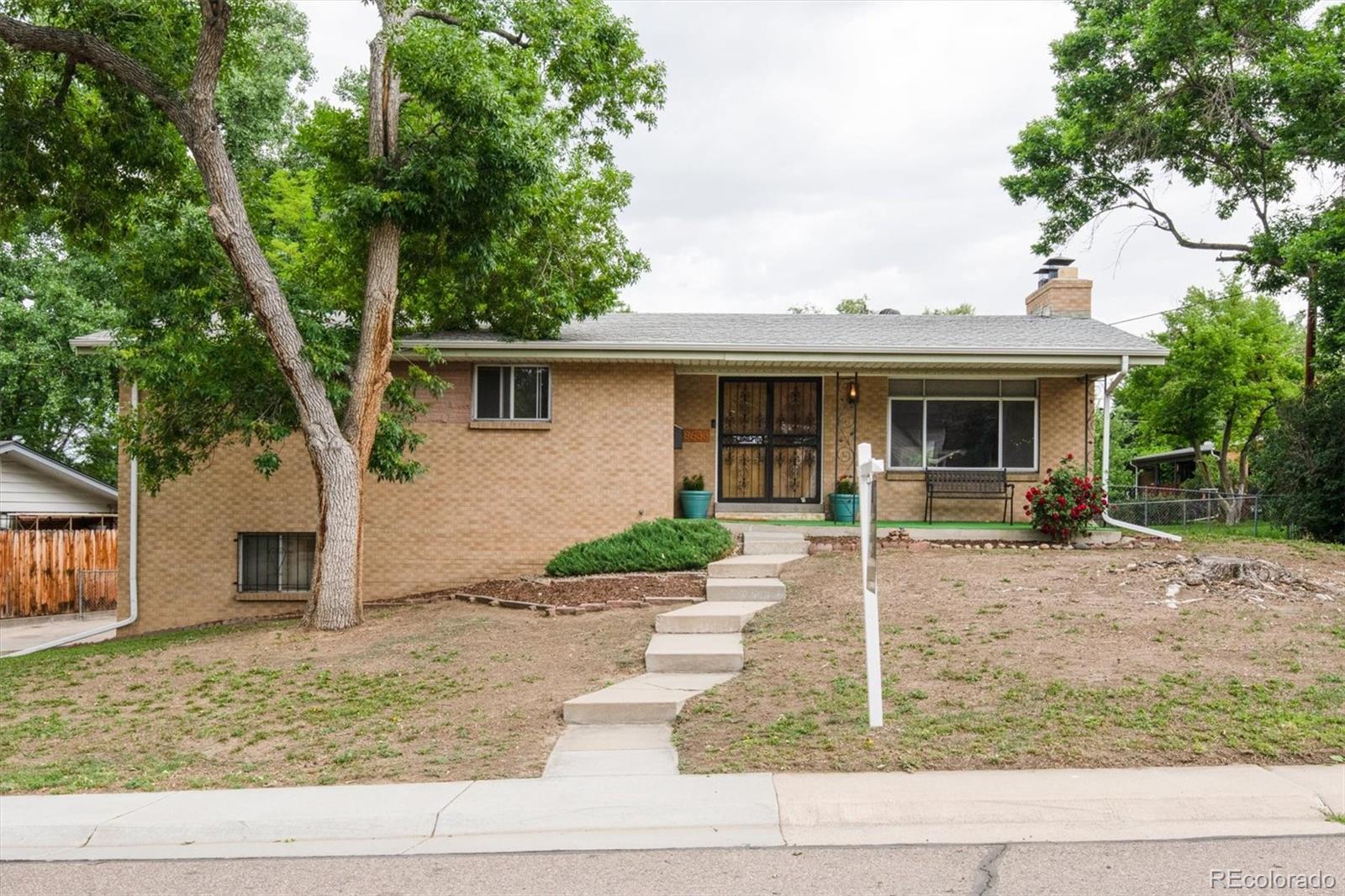 a view of a house with a yard and large tree