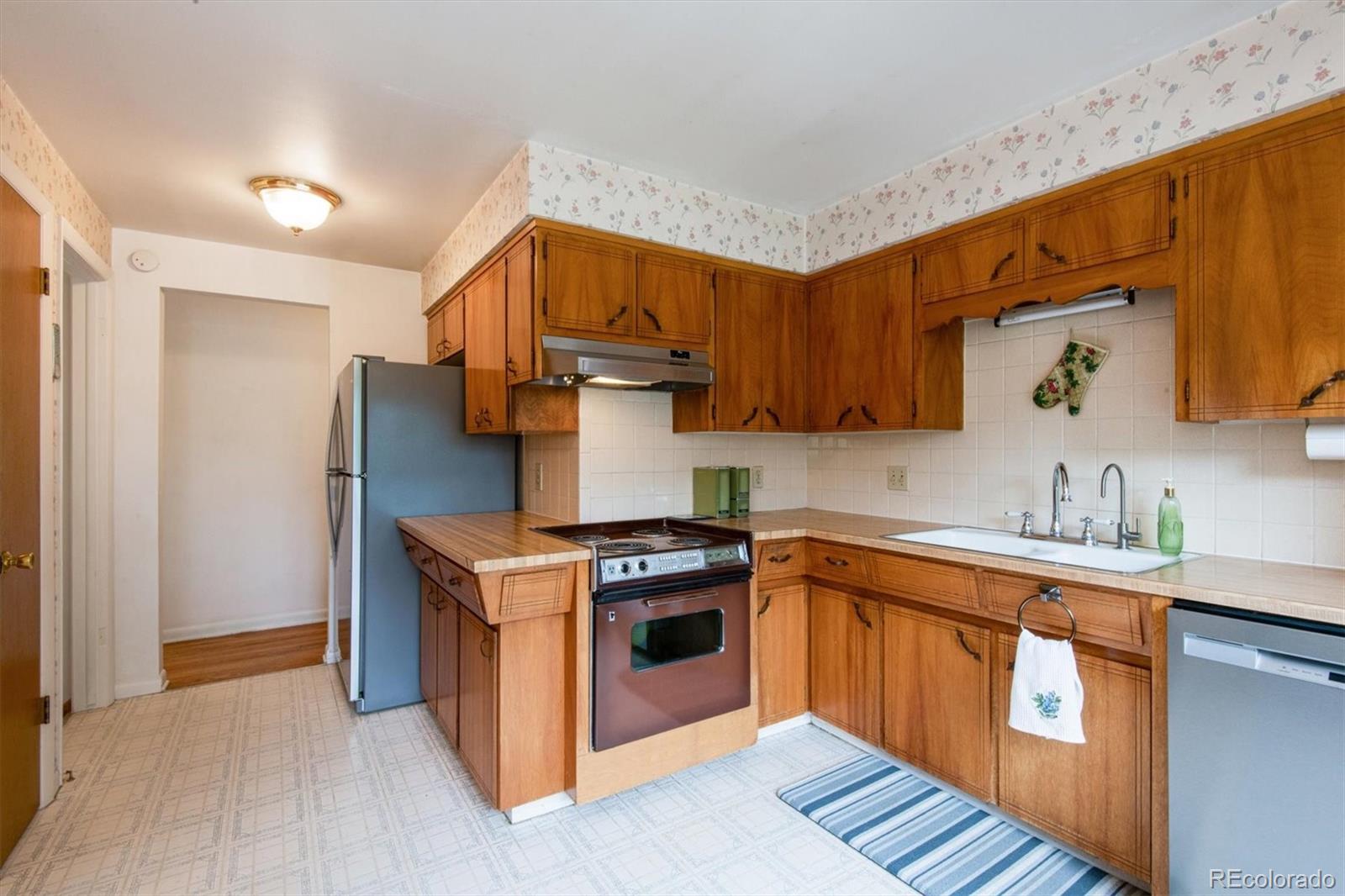 8633 West 44th Place Wheat Ridge, CO 80033 - Photo 11 of 30 a kitchen with stainless steel appliances granite countertop a stove a sink dishwasher and a refrigerator