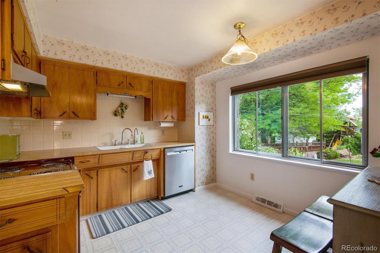 8633 West 44th Place Wheat Ridge, CO 80033 - Photo 12 of 30 a kitchen with stainless steel appliances granite countertop a sink and a stove