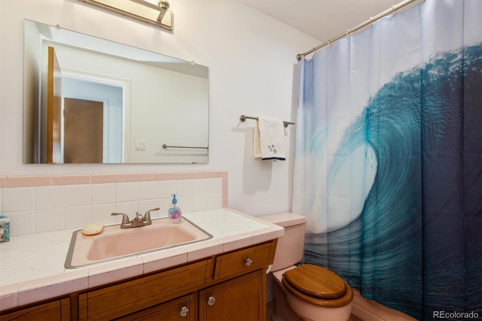 8633 West 44th Place Wheat Ridge, CO 80033 - Photo 15 of 30 a bathroom with a sink a toilet and shower