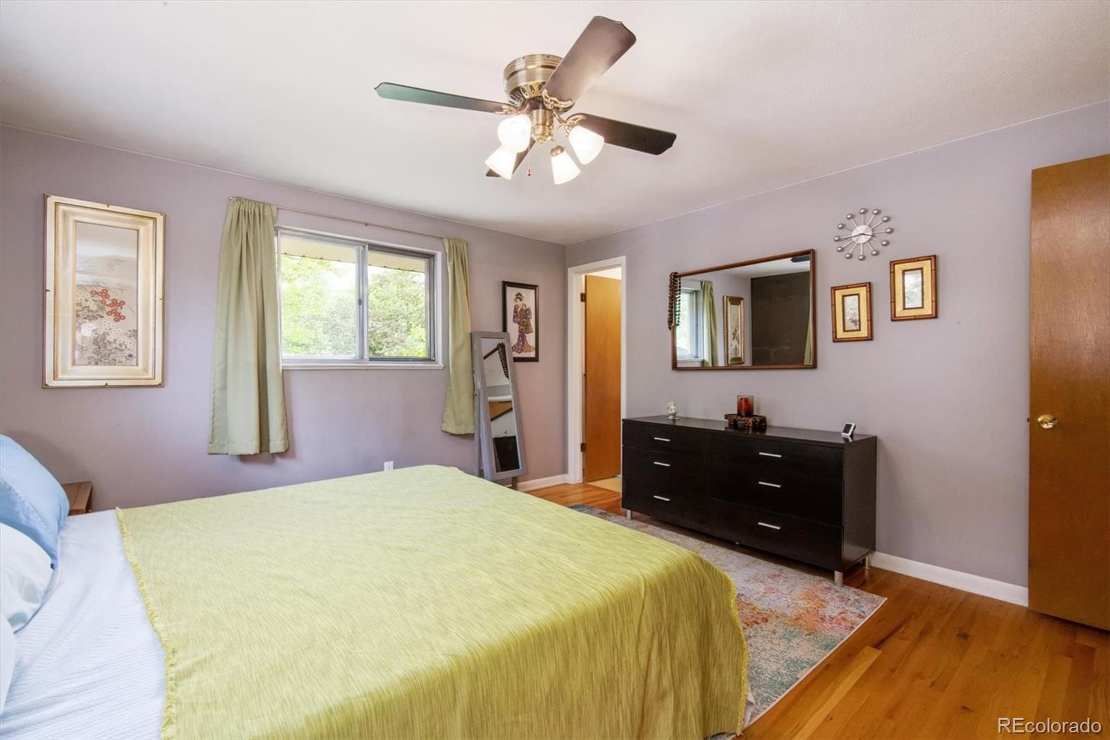 8633 West 44th Place Wheat Ridge, CO 80033 - Photo 17 of 30 a bedroom with a bed and wooden floor