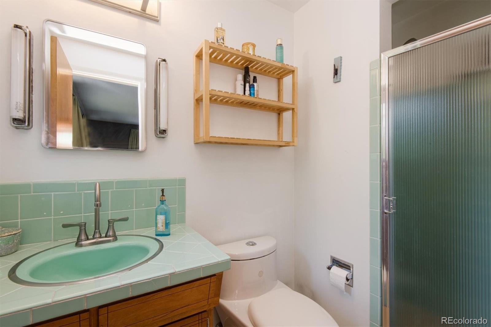 8633 West 44th Place Wheat Ridge, CO 80033 - Photo 19 of 30 a bathroom with a toilet sink and mirror