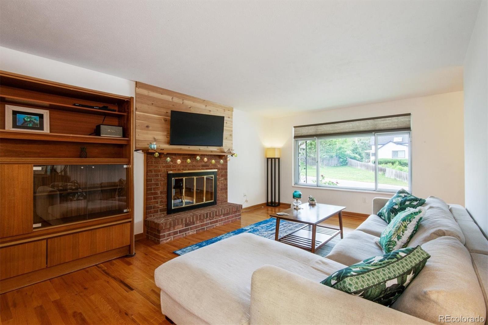 8633 West 44th Place Wheat Ridge, CO 80033 - Photo 5 of 30 a living room with furniture a flat screen tv and a fireplace