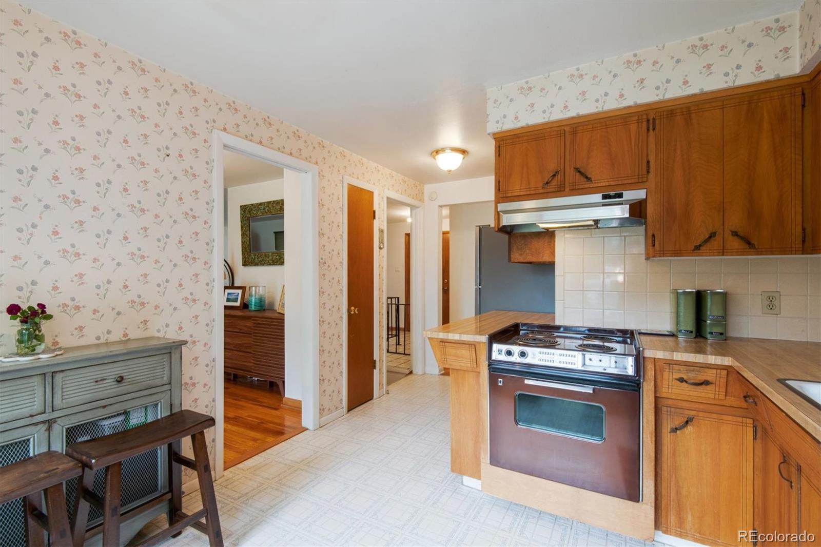8633 West 44th Place Wheat Ridge, CO 80033 - Photo 10 of 30 a kitchen with stainless steel appliances granite countertop a stove and a refrigerator