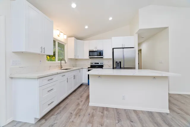 a view of a kitchen with a sink and a large window