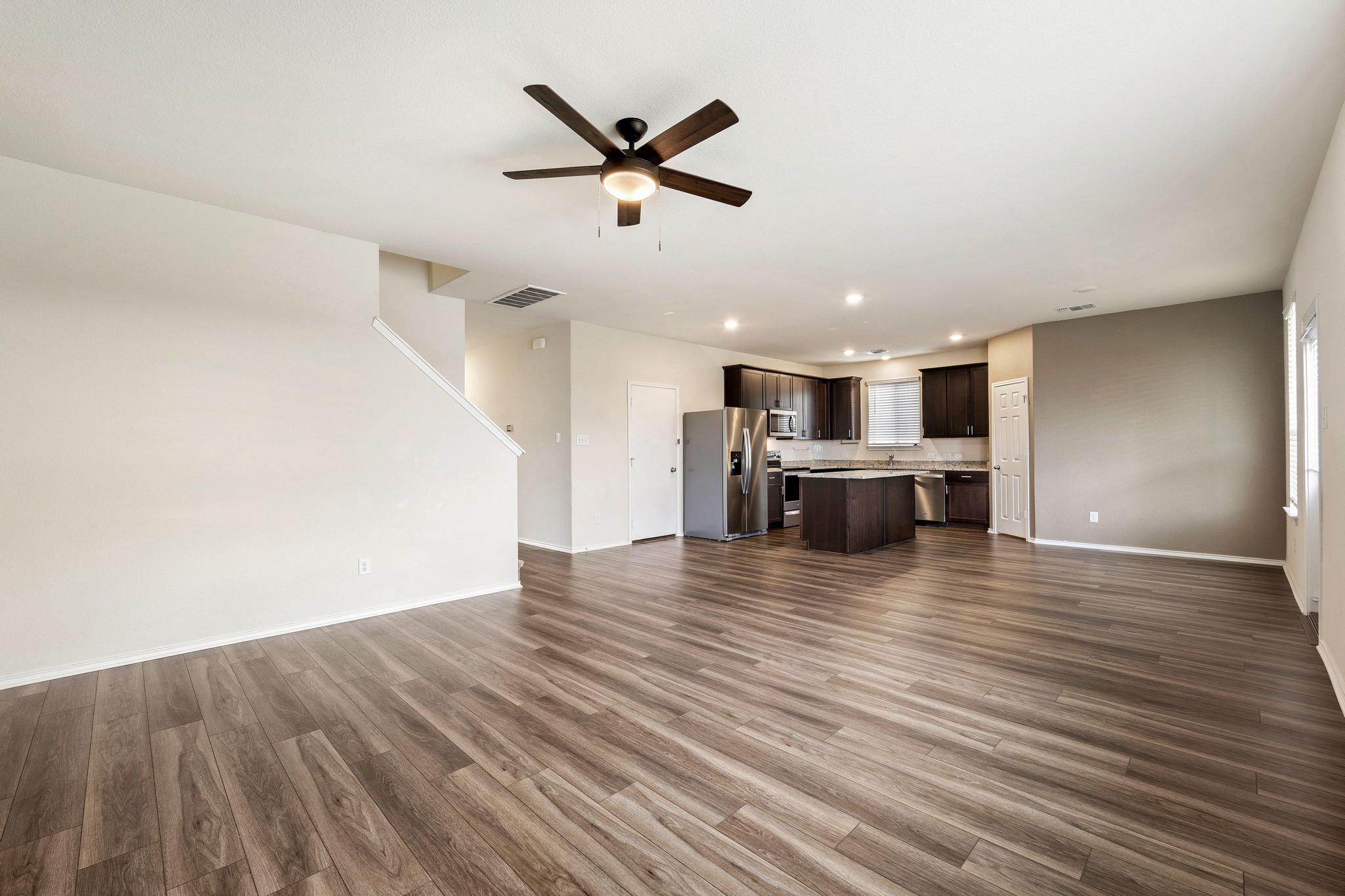 217 Innisfree Road Jarrell, TX 76537 - Photo 38 of 39 An open floorplan seamlessly connects the living space to a modern kitchen, featuring recessed lighting and durable flooring. Living room is open to the kitchen