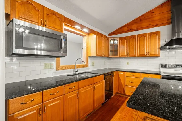 a kitchen with stainless steel appliances granite countertop a sink a stove and cabinets