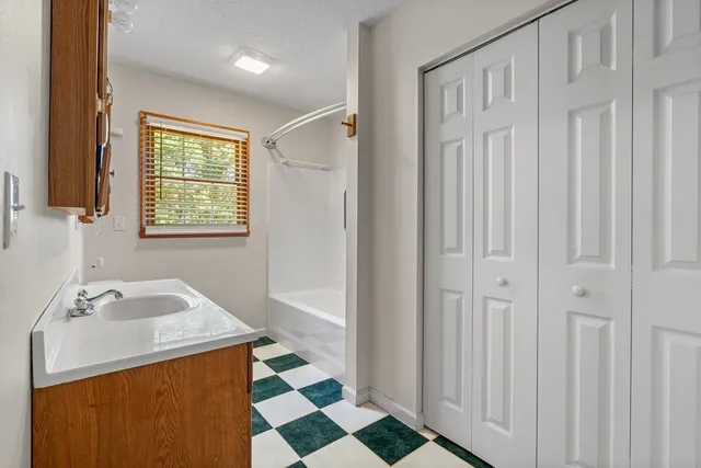 a bathroom with a sink a toilet and a window