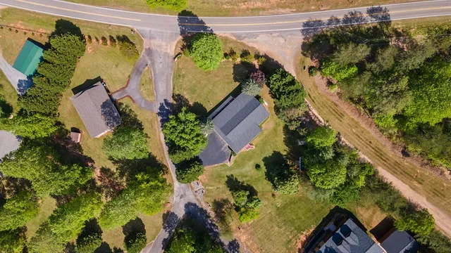 an aerial view of a house with swimming pool and a yard