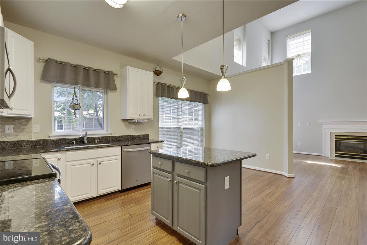 12902 Summit Ridge Terrace Germantown, MD 20874 - Photo 12 of 30 a kitchen with stainless steel appliances granite countertop a sink a stove and a wooden floors