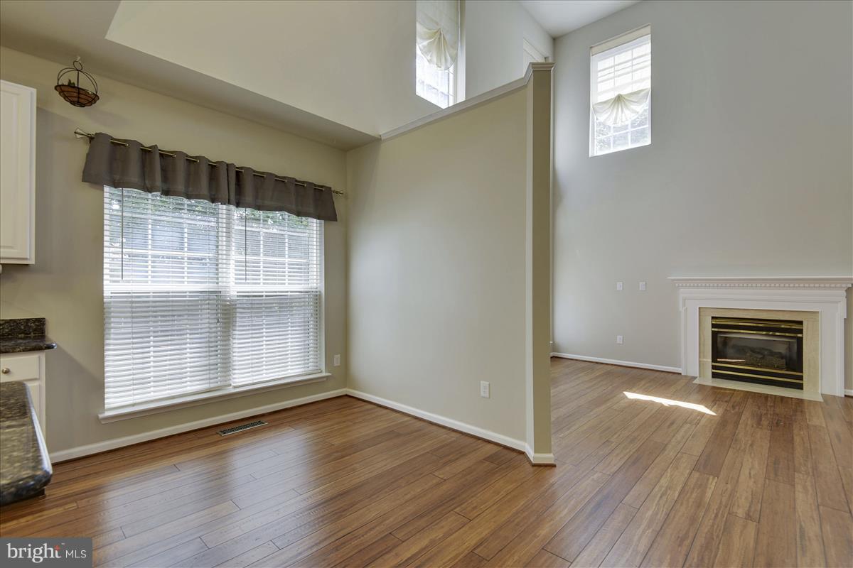 12902 Summit Ridge Terrace Germantown, MD 20874 - Photo 15 of 30 an empty room with wooden floor cabinet and windows