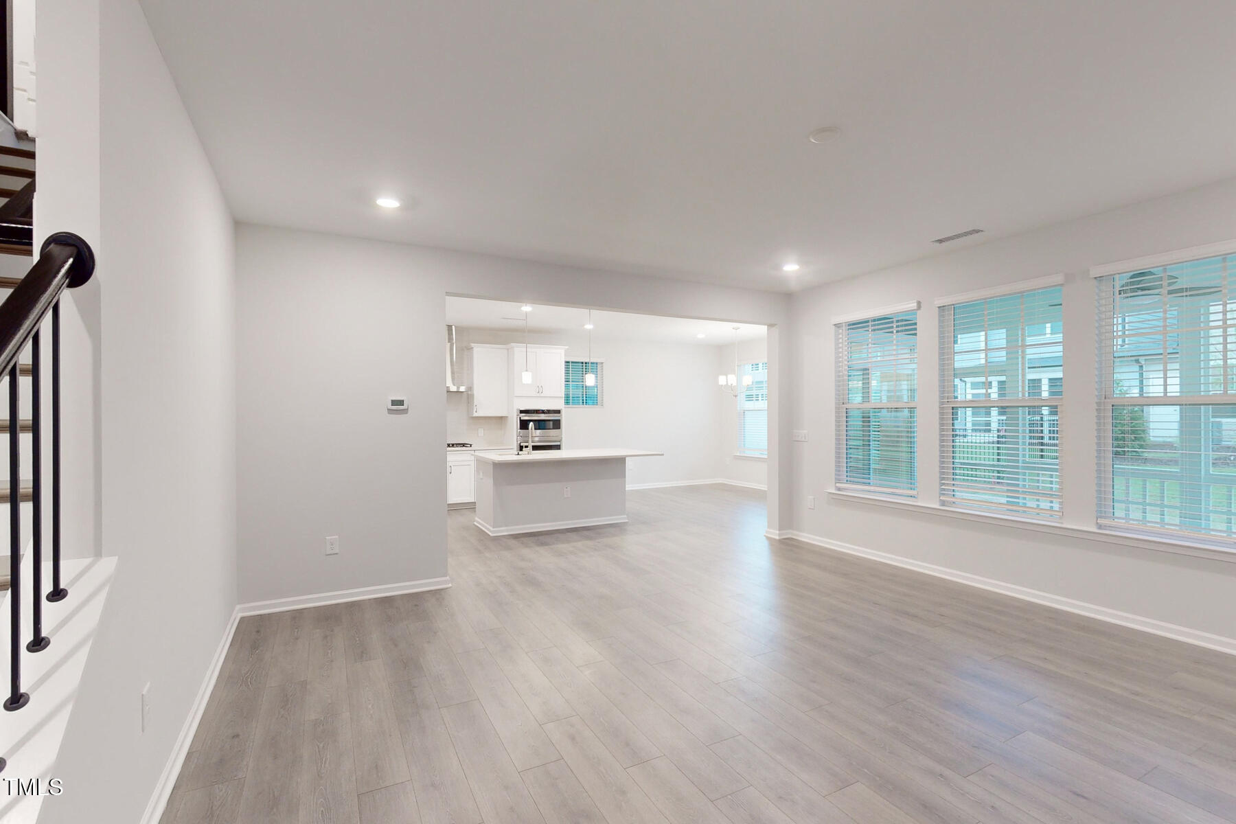 7701 Litcham Drive Raleigh, NC 27615 - Photo 15 of 58 a view of a big room with wooden floor and windows