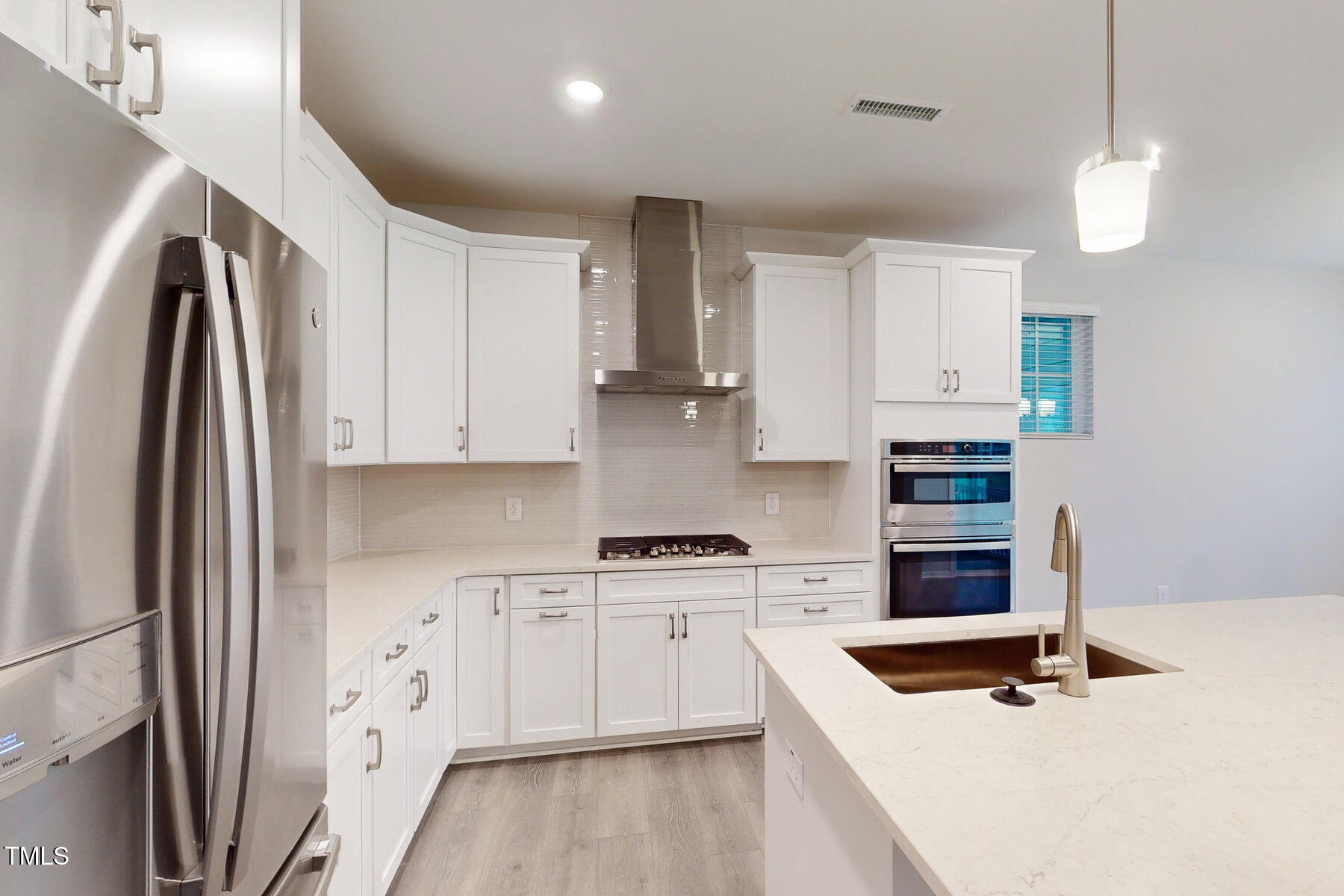 7701 Litcham Drive Raleigh, NC 27615 - Photo 19 of 58 a kitchen with stainless steel appliances granite countertop a refrigerator sink and white cabinets