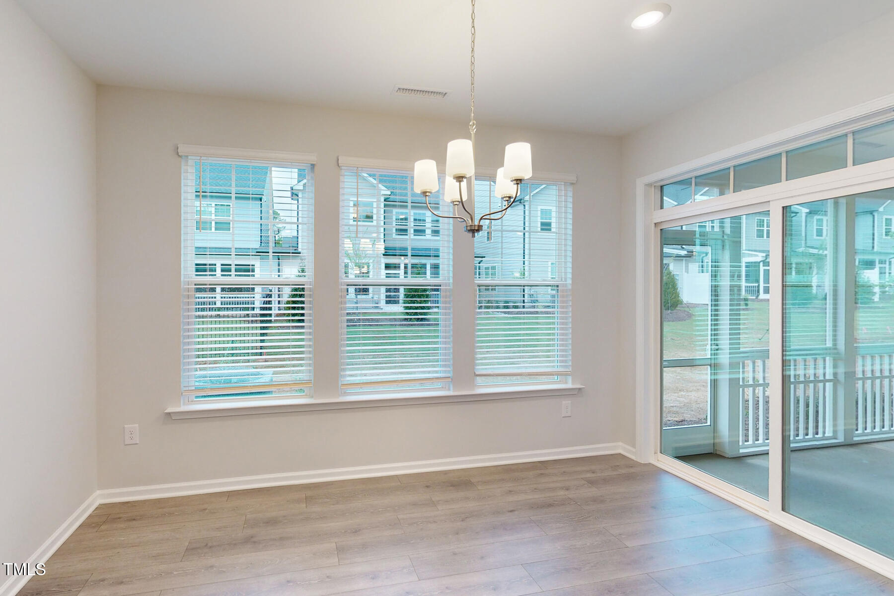 7701 Litcham Drive Raleigh, NC 27615 - Photo 22 of 58 a view of an empty room with wooden floor and a window