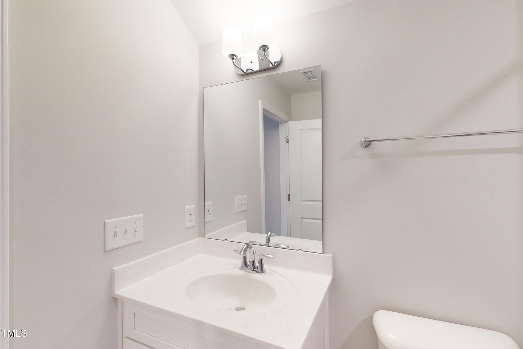 7701 Litcham Drive Raleigh, NC 27615 - Photo 50 of 58 a bathroom with a sink a toilet and mirror