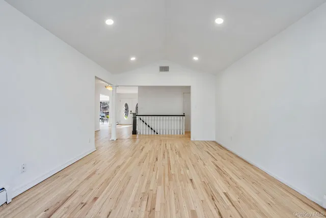 a view of a room with wooden floor and a ceiling fan