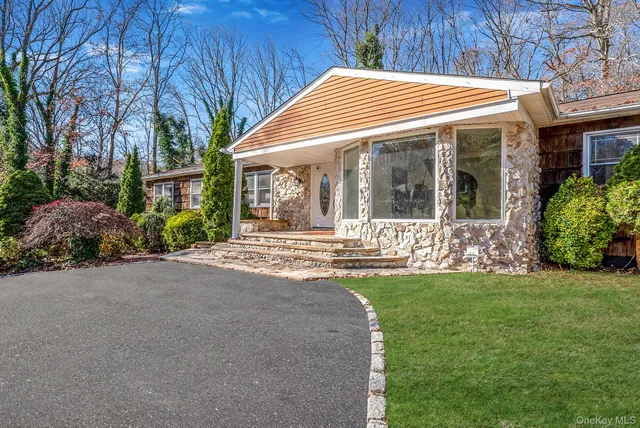 a front view of a house with a garden and yard