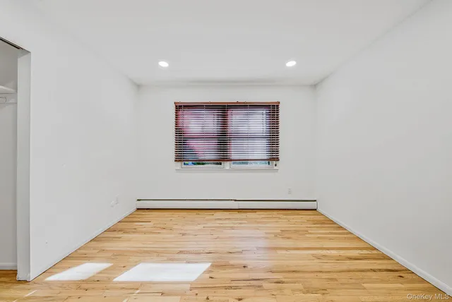a view of a room with wooden floor and a window
