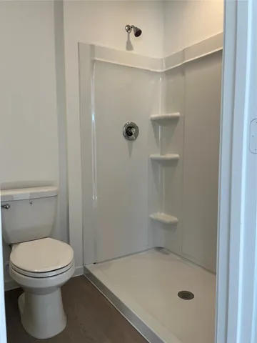a bathroom with a toilet and a shower
