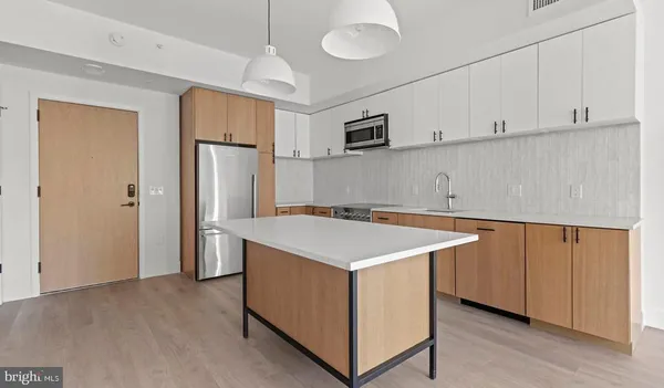 a kitchen with stainless steel appliances cabinets and wooden floor