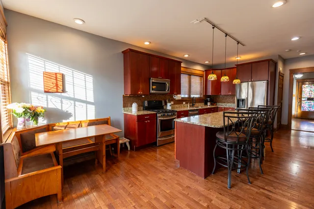 a kitchen with a table chairs refrigerator and microwave