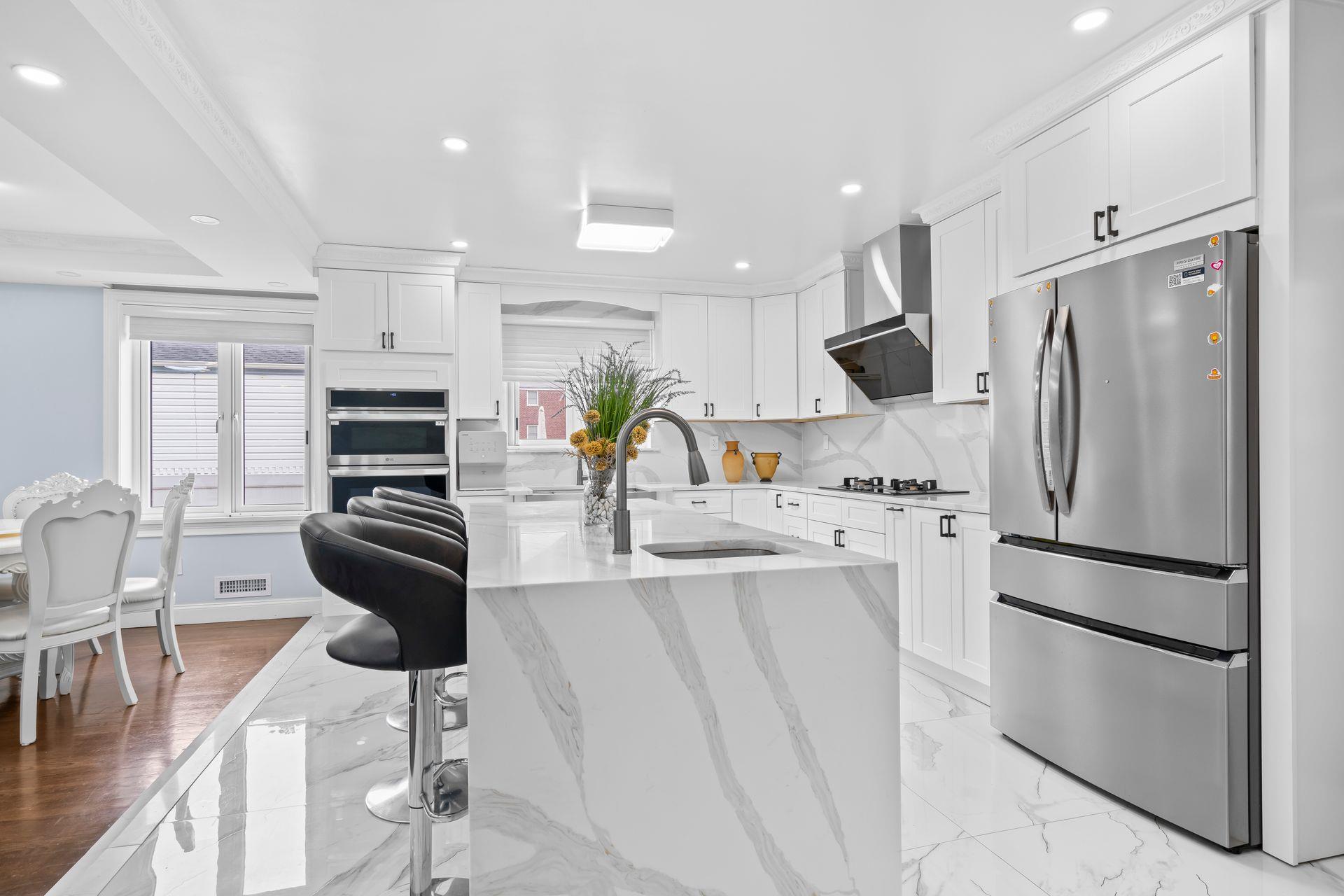 63-41 252nd Street Queens, NY 11362 - Photo 12 of 39 a kitchen with stainless steel appliances a refrigerator stove microwave and cabinets