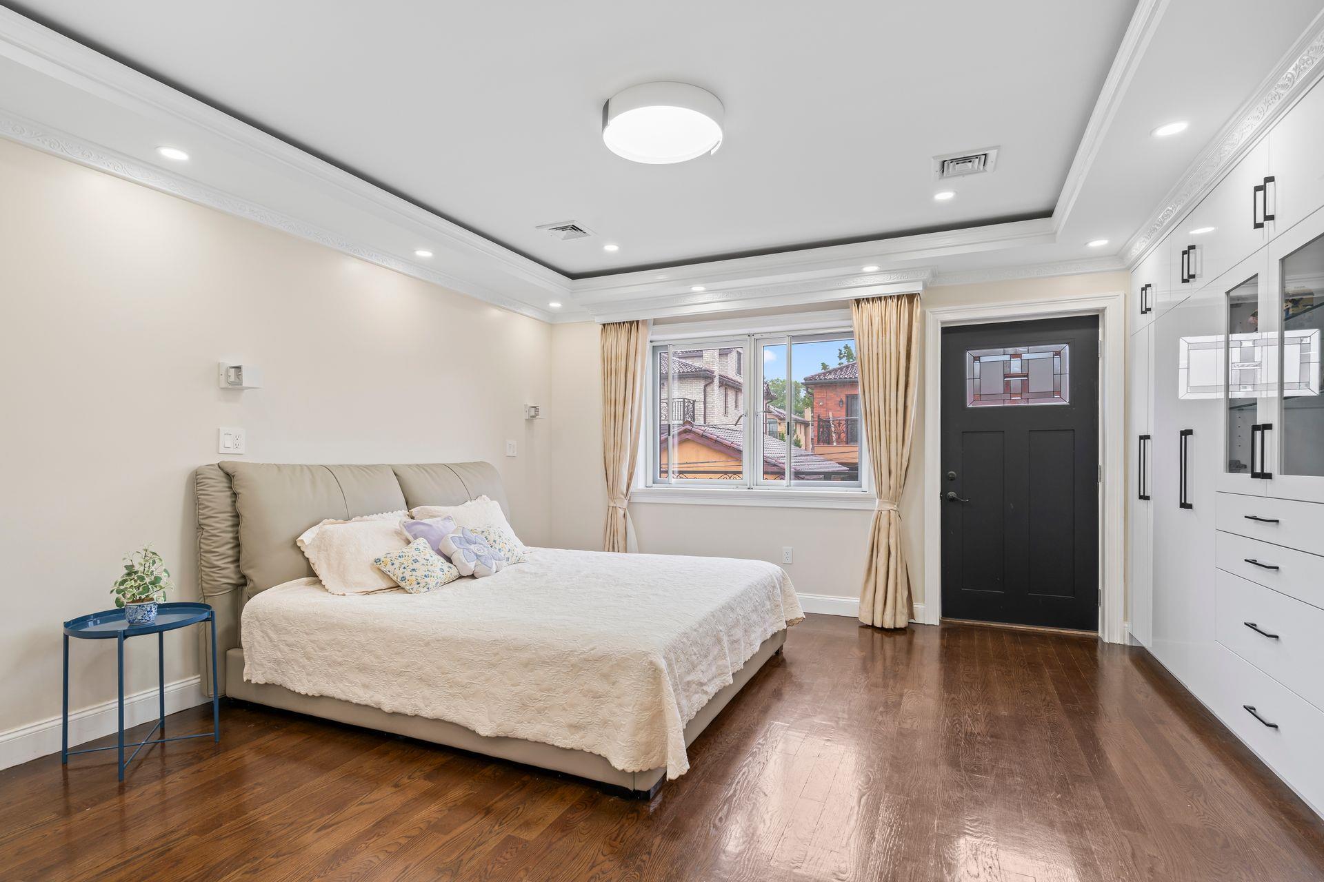 63-41 252nd Street Queens, NY 11362 - Photo 27 of 39 a bedroom with a large bed and painting on the wall