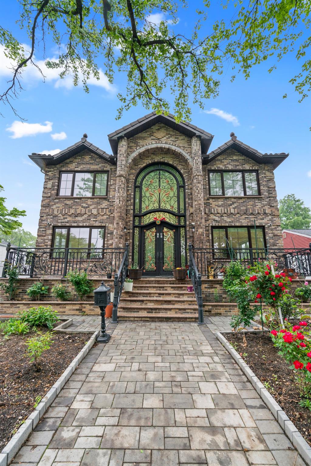 63-41 252nd Street Queens, NY 11362 - Photo 3 of 39 a view of a brick house with a small yard plants and large tree
