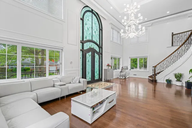 a living room with furniture chandelier and a large window