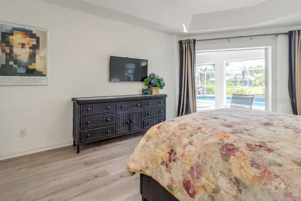 a spacious bedroom with a bed and a flat screen television