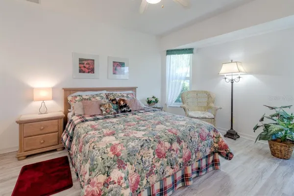 a bedroom with a bed and a lamp on dresser