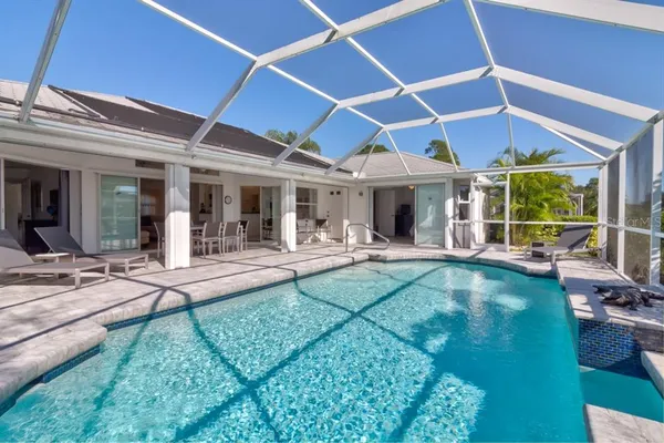 a view of a backyard with swimming pool and patio