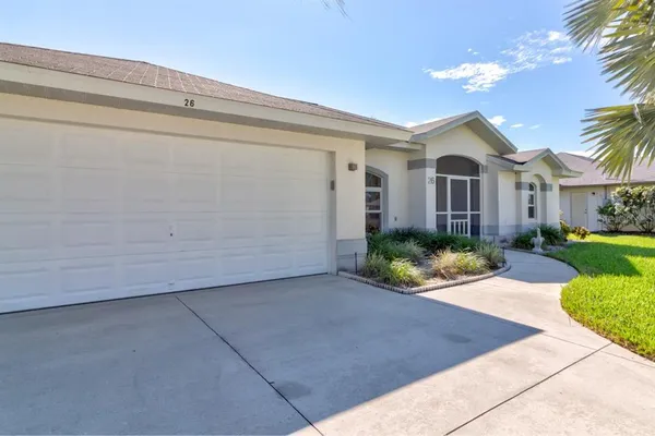 a front view of a house with a yard and potted plants