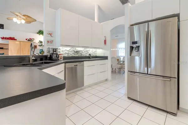 a kitchen with granite countertop a refrigerator and a sink
