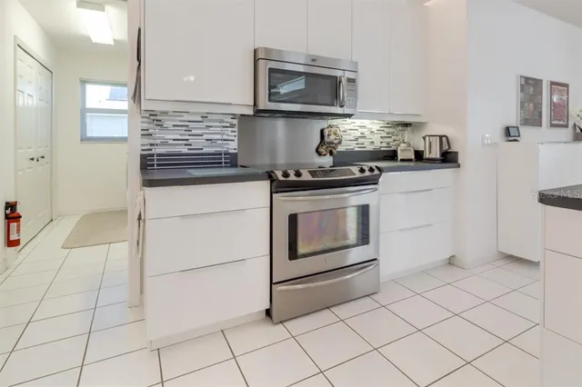 a kitchen with stainless steel appliances granite countertop a stove a microwave and a refrigerator